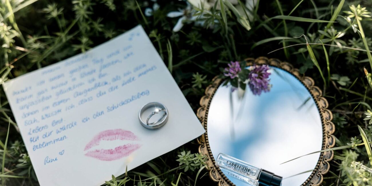Detailaufnahme Liebesbrief mit Spiegel und Ringen