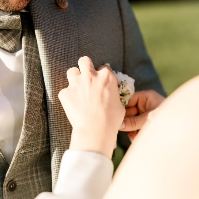 Boutonniere Bräutigam wird durch die Braut gerichtet